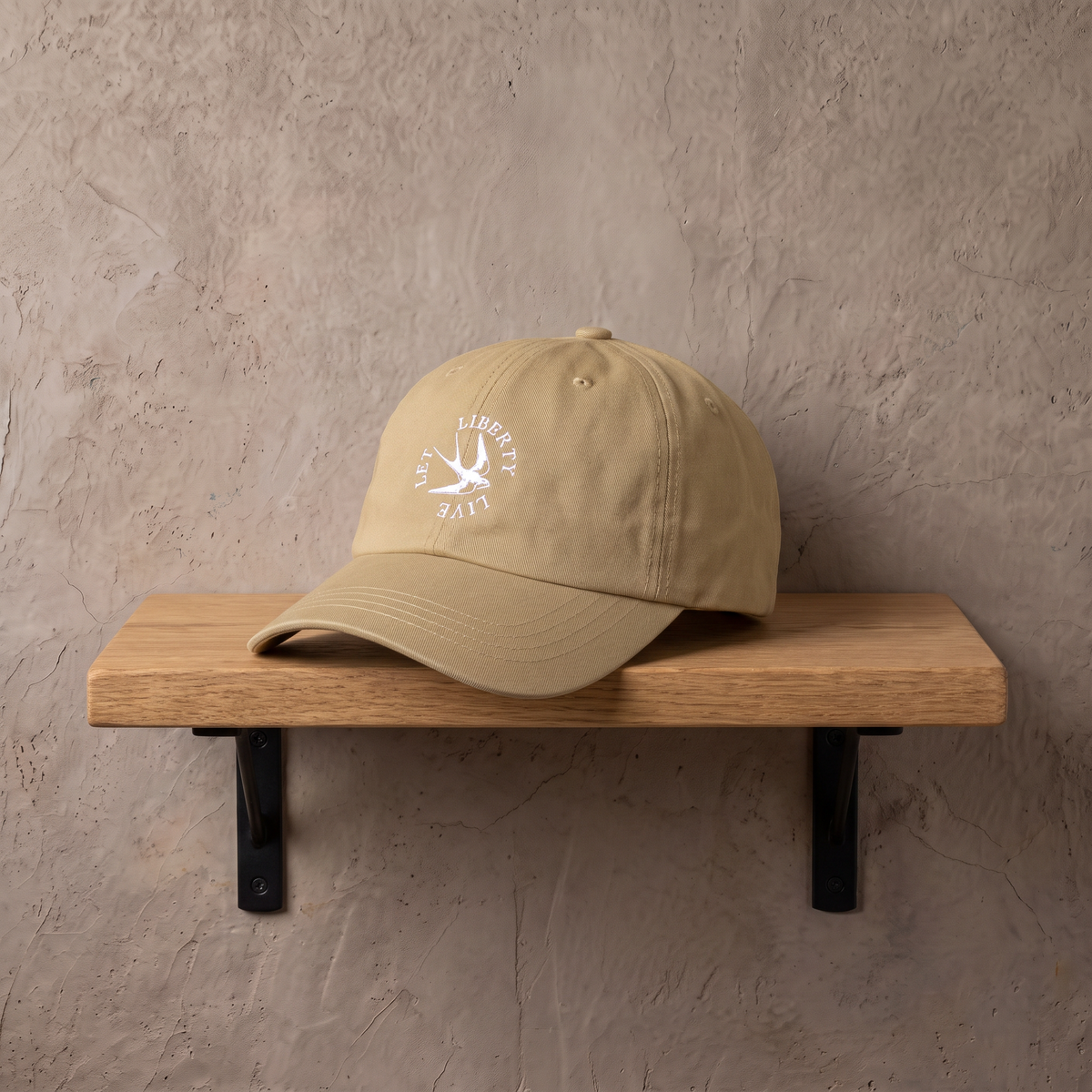 Let Liberty Live cap op een eiken wandplank tegen een stucwerk muur
