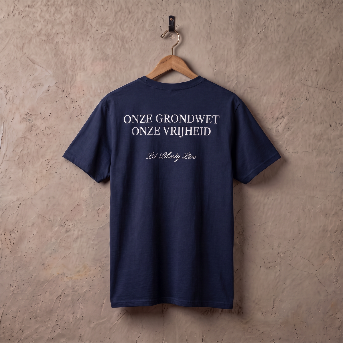 Navy t-shirt Grondrecht = vrijheid aan een houten hanger tegen een stucwerk muur